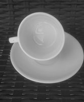tilted White Porcelain Tea Cup on a Saucer